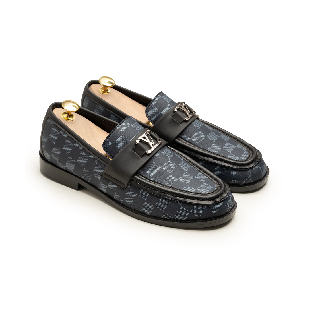 Pair of checkered loafers with gold accents on a white background